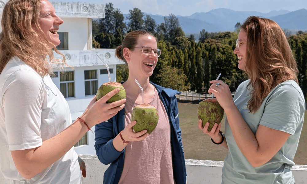 Students Enjoying Fresh Coconut Water on Ashram Rooftop Terrace