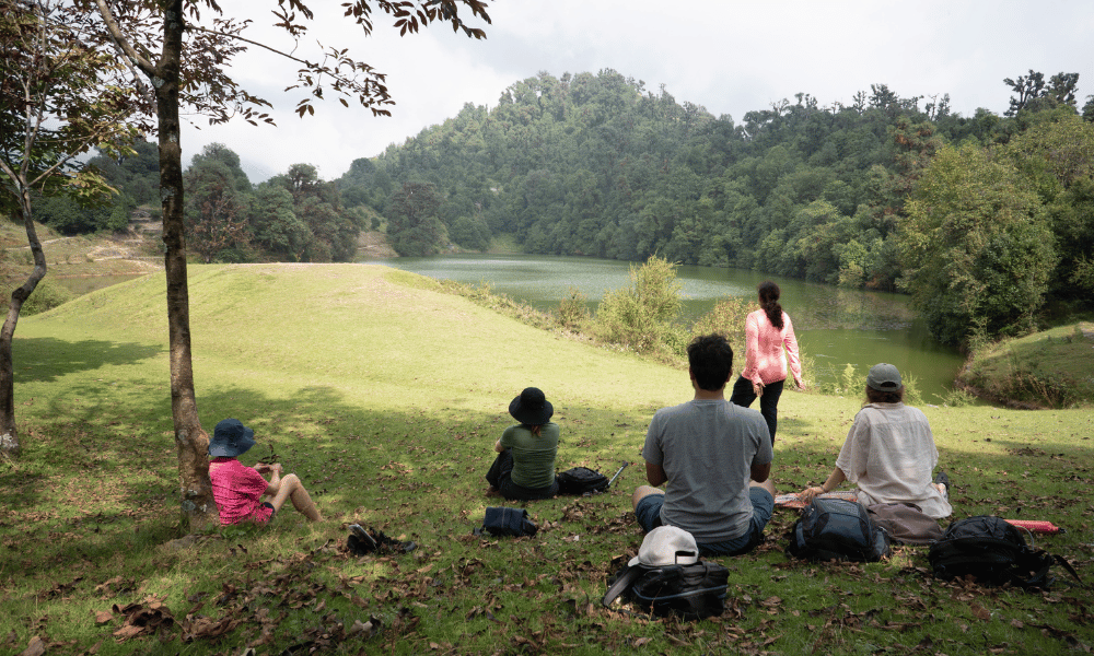 Yoga Students Relaxing on Lush Meadow by Deoria Tal Lake